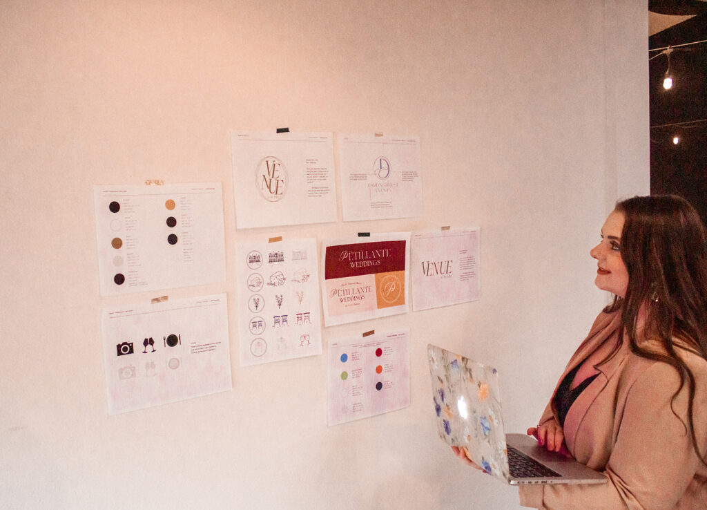 Emily Foster, owner of Emily Foster Creative, looking at brand designs for a wedding business.