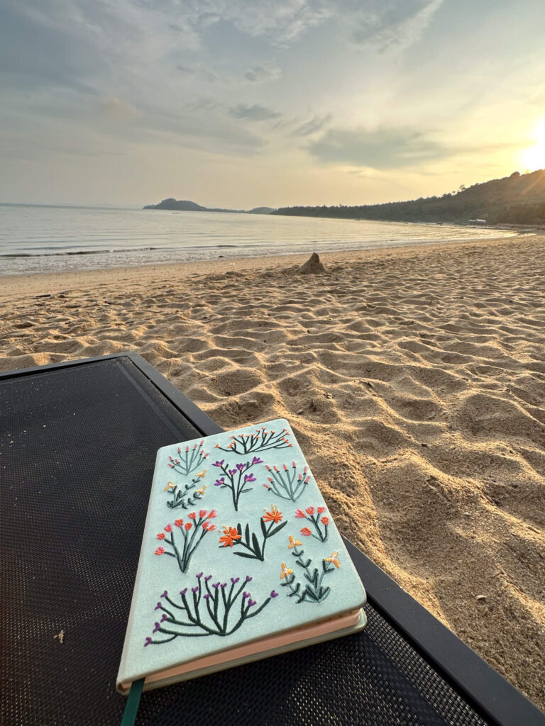journaling on the beach at Coconut island outside of Phuket, Thailand
