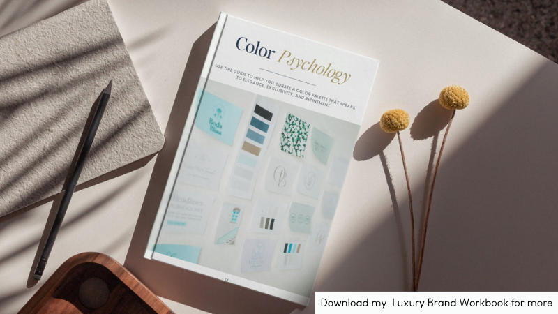 A flatlay of a “Color Psychology” branding workbook on a light desk, next to flowers and soft shadows.