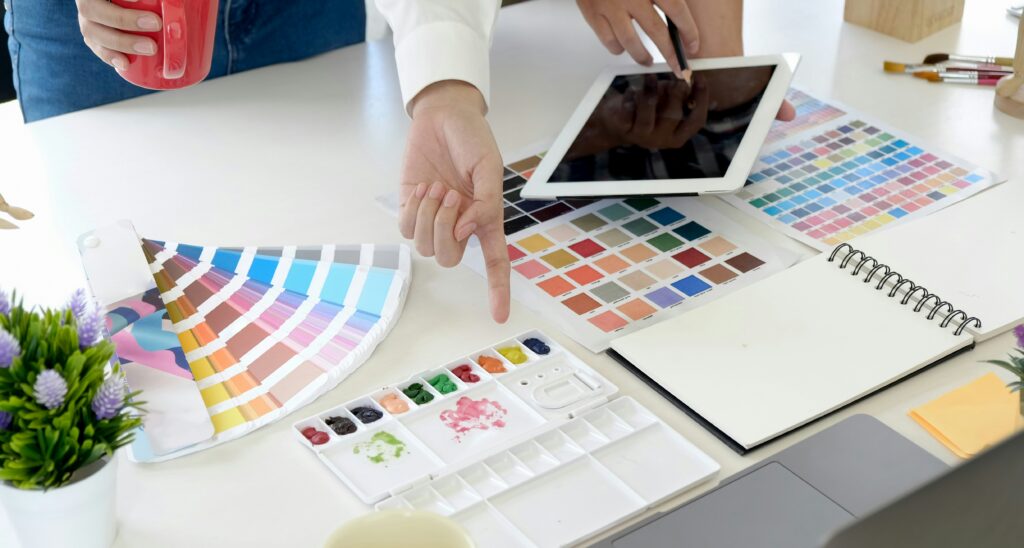 Creative team working with paint swatches, tablet, and color palette tools during a design session