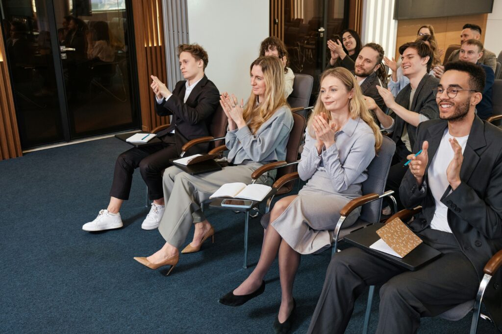 Group of people listening to a gathering clapping their hands