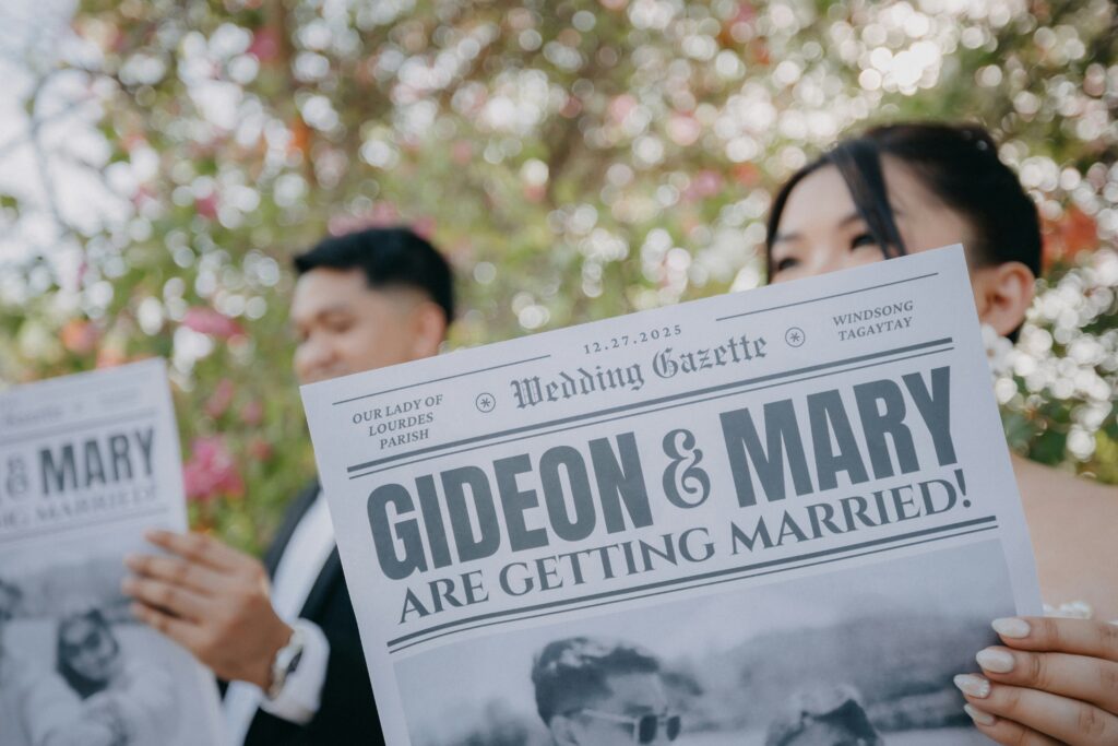 Bride and groom holding a newspaper that has their wedding as headline