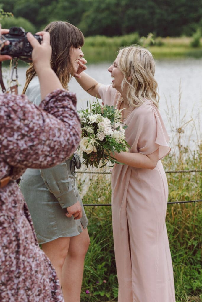 Wedding vendors capturing and adjusting details during an outdoor wedding setup