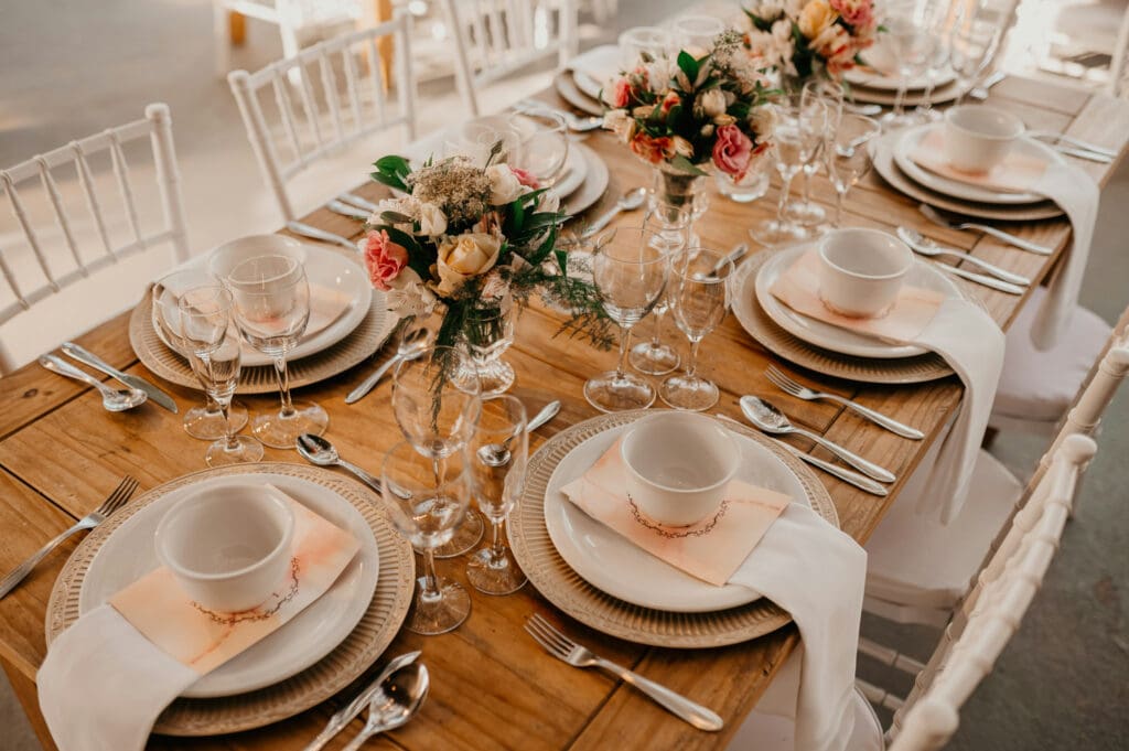 Wedding reception table set with place settings, flowers, and glassware