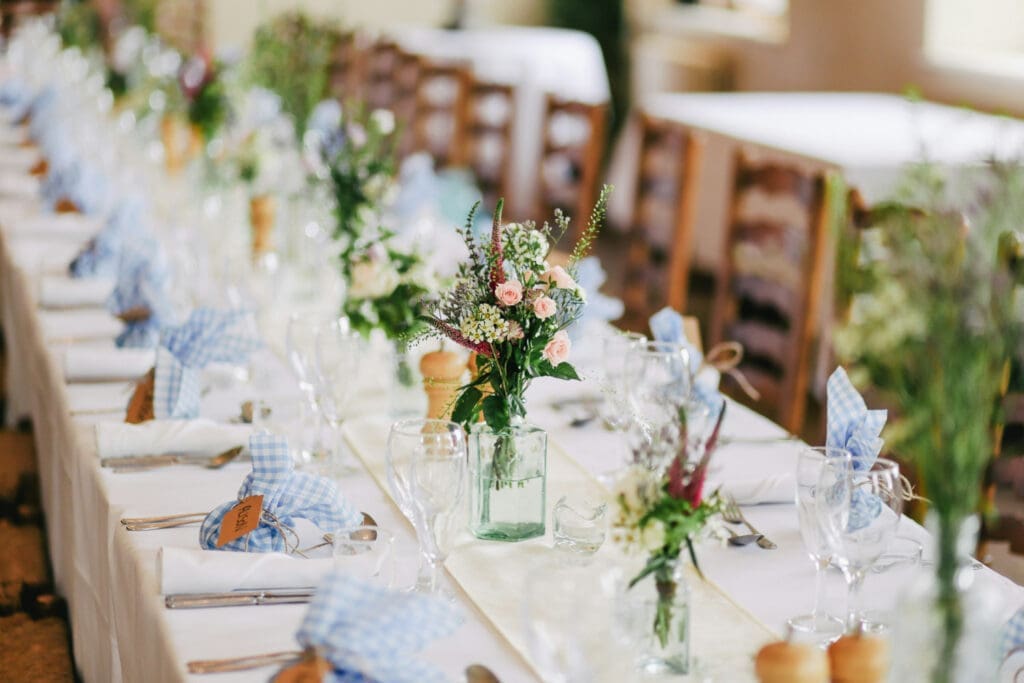 Long wedding reception table decorated with flowers and place settings