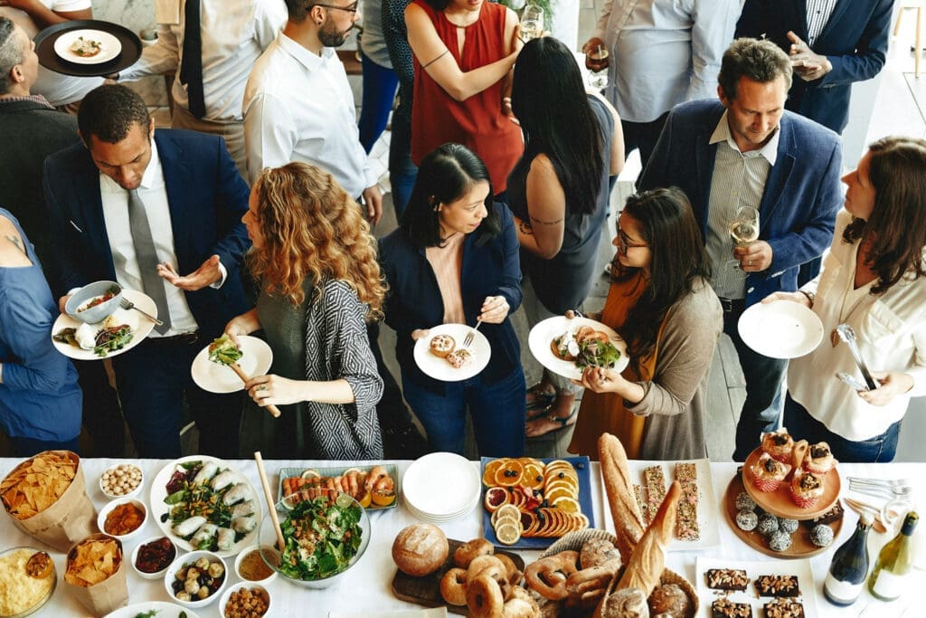 Guests gathering around a catered buffet table at an event