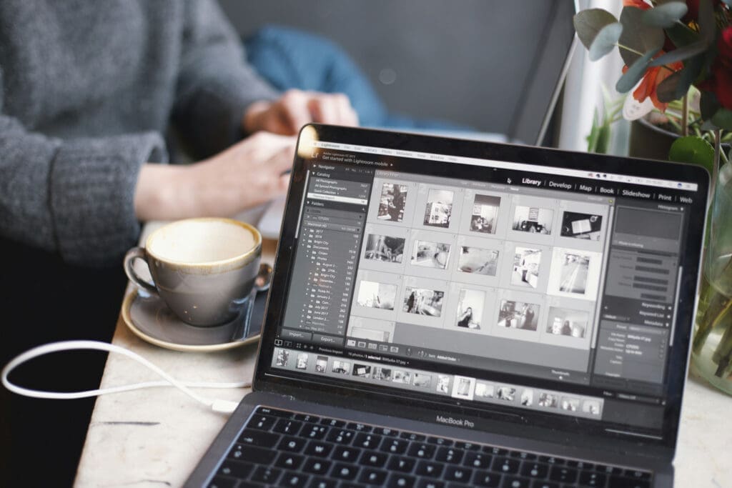 Laptop displaying photo editing software on a café table