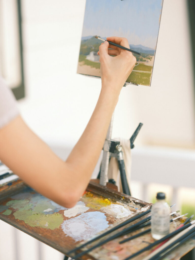 Artist painting a landscape on canvas