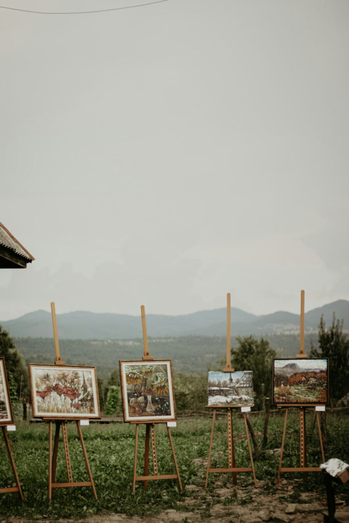 Paintings displayed on easels at an outdoor event