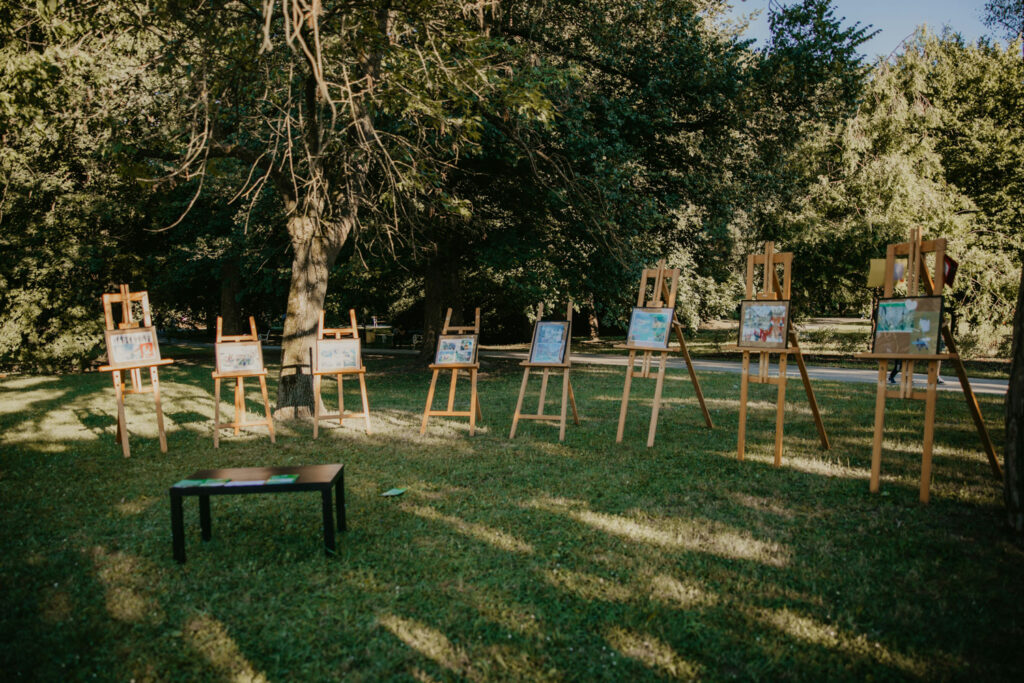 Paintings displayed on easels in a park