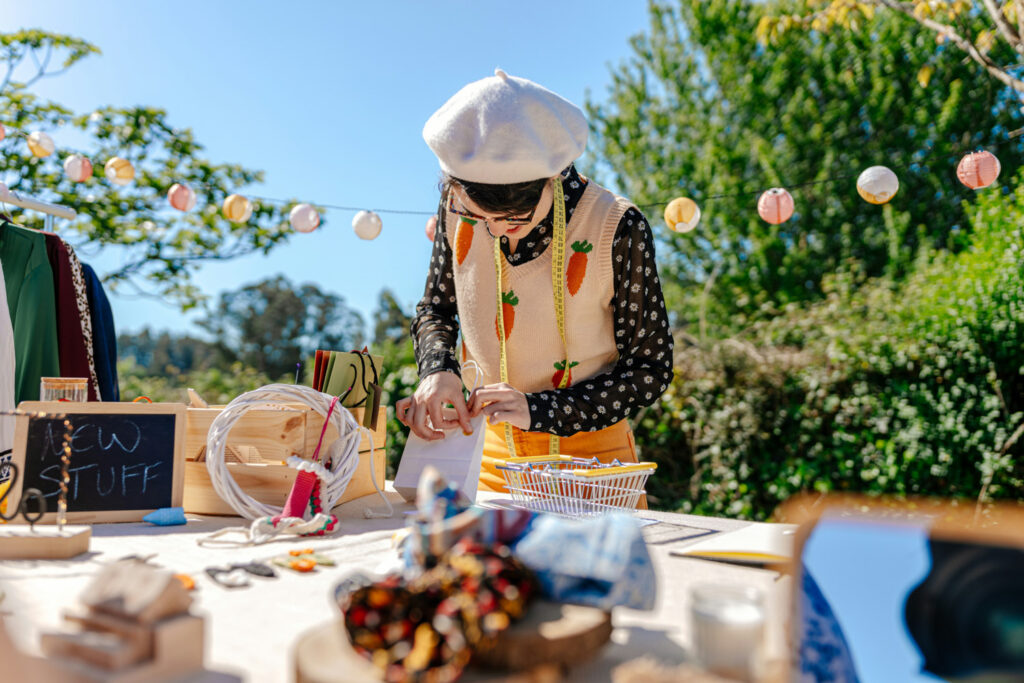 Vendor arranging handmade items at an outdoor market