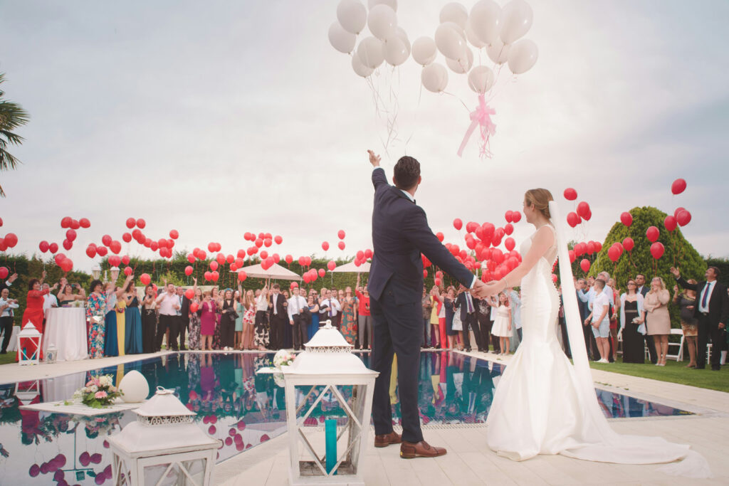 Couple celebrating with guests at a poolside wedding