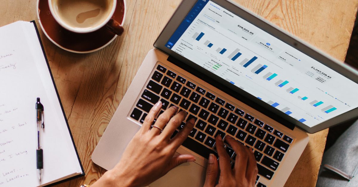 Event rental business owner reviewing the Goodshuffle Pro financial overview dashboard on a laptop next to a cup of coffee