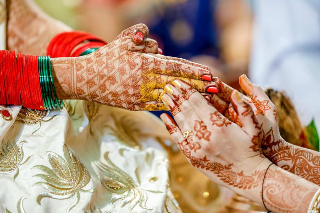Henna-decorated hands during a traditional wedding ceremony.