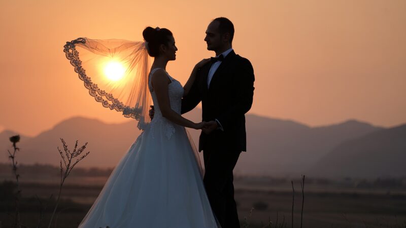 Bride and groom holding hands at sunset.