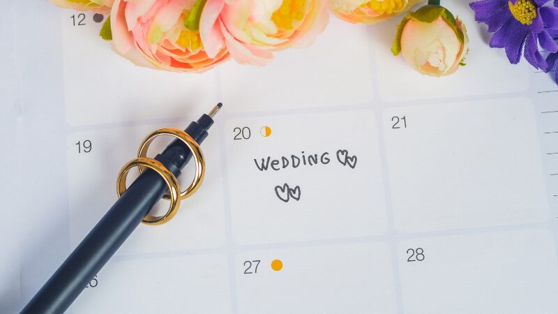 Wedding date marked on a calendar with rings and flowers.
