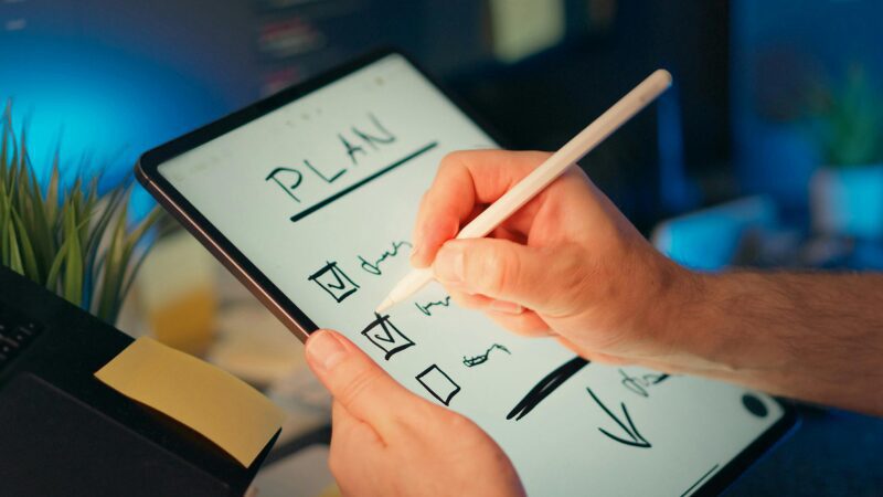 Hand writing a checklist on a tablet