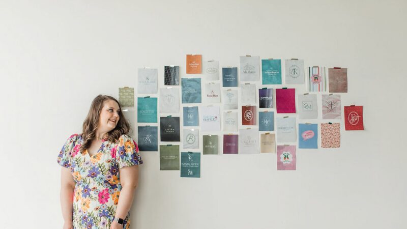 Emily standing beside a wall of branding samples