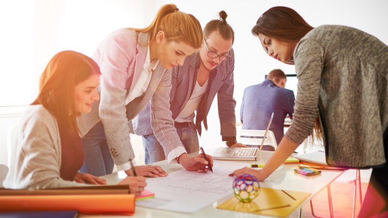 Women collaborating on plans at a work table