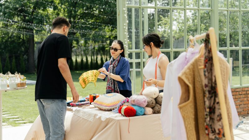 Vendors arranging handmade items at an outdoor market